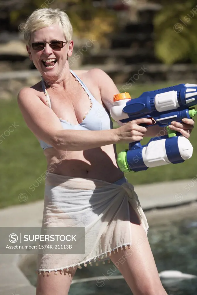Mature woman spraying water with a squirt gun