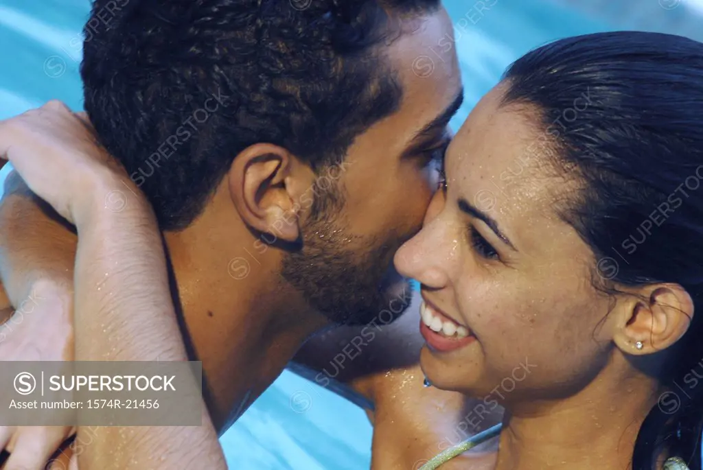 Close-up of a young couple embracing each other in a swimming pool