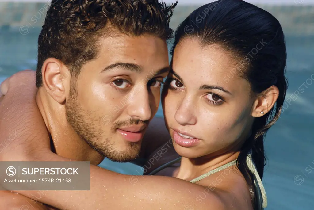 Portrait of a young couple embracing each other in a swimming pool