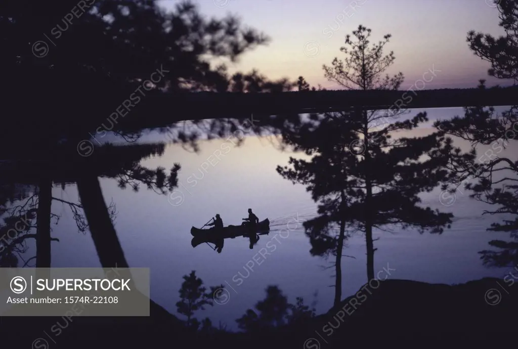 Silhouette of two people in a canoe, Canada