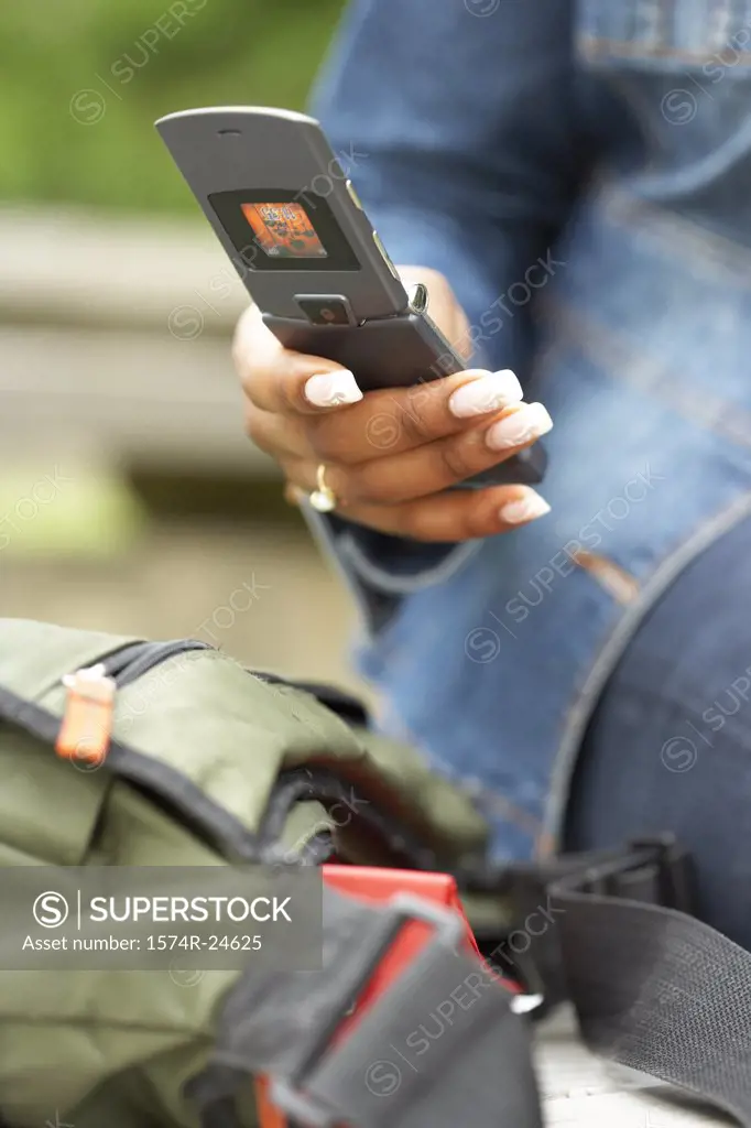 Mid section view of a college student using a mobile phone