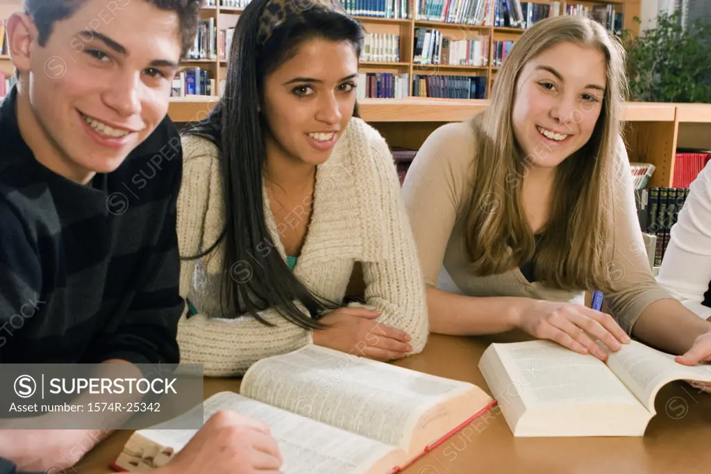 Three students sitting at a table in a library