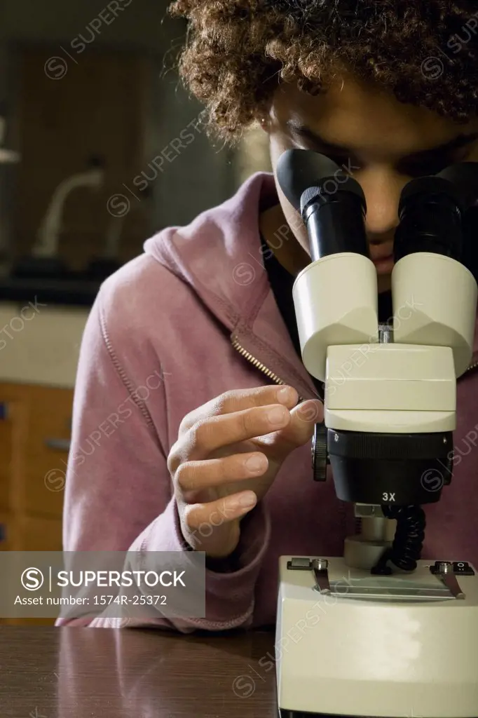 Close-up of a student looking through a microscope
