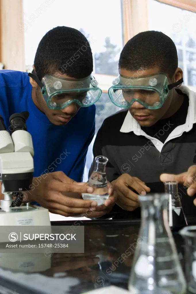 Two student looking at a beaker in a science lab