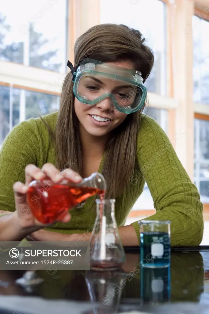 Student pouring liquid in a beaker in a science lab