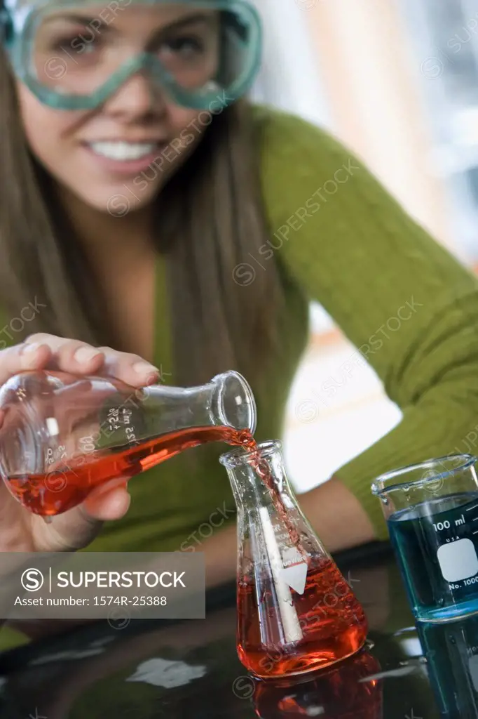 Close-up of a student pouring liquid in a beaker in a science lab