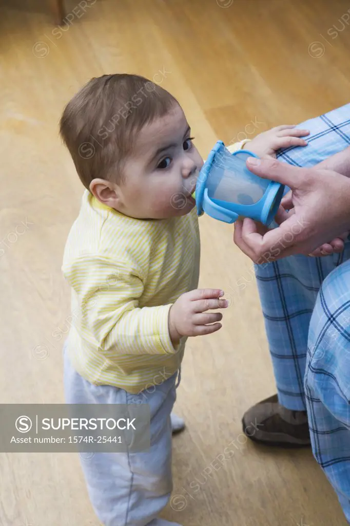 High angle view of a baby boy drinking from a cup