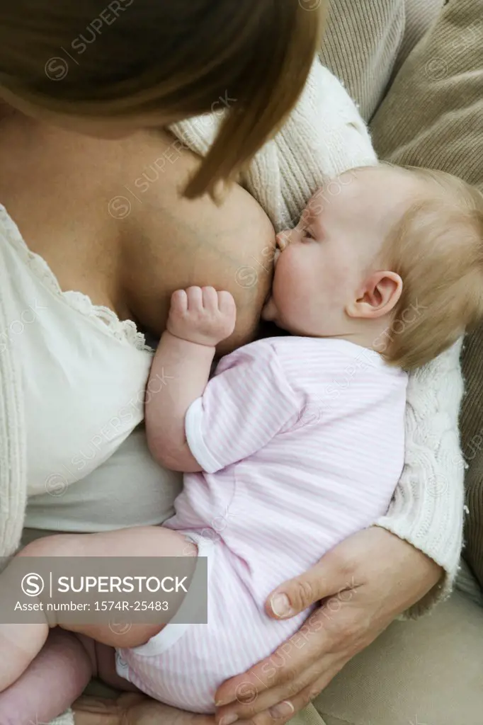 Close-up of a mid adult woman breastfeeding her daughter