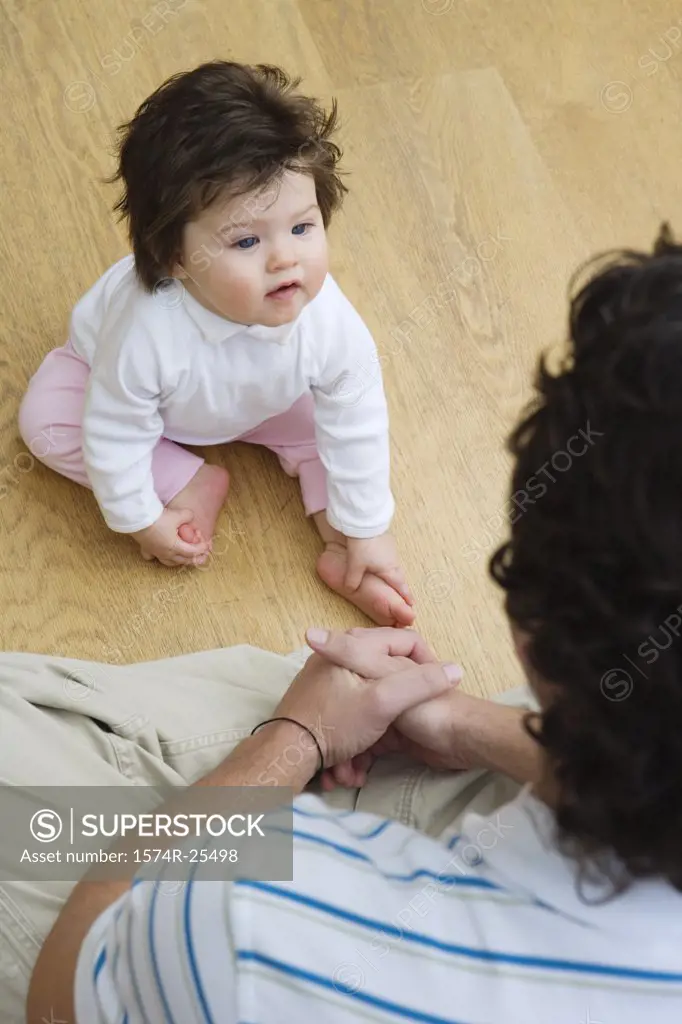 High angle view of a baby girl sitting in front of her father