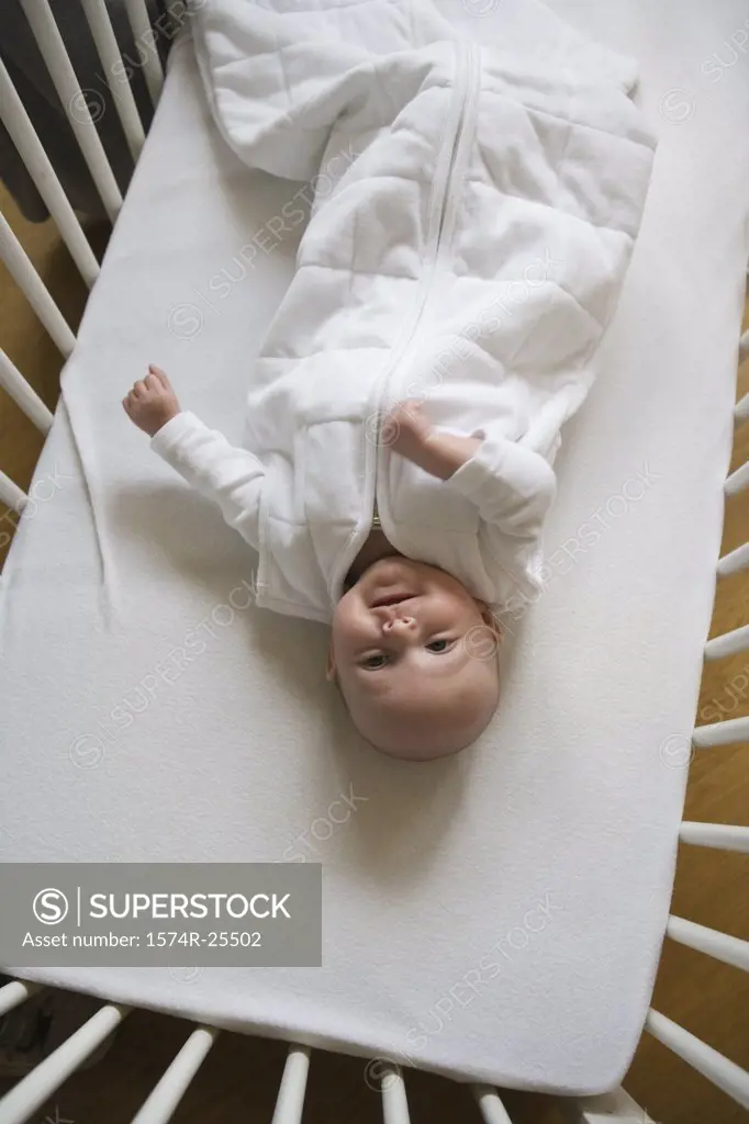 High angle view of a baby lying in a crib