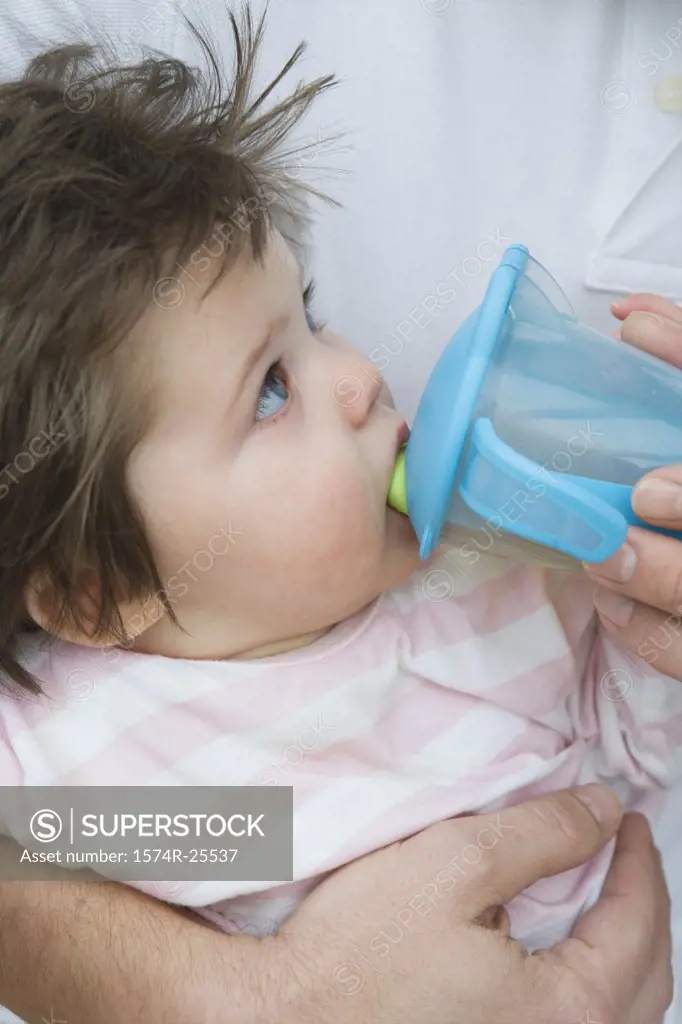Close-up of a baby girl drinking from a cup