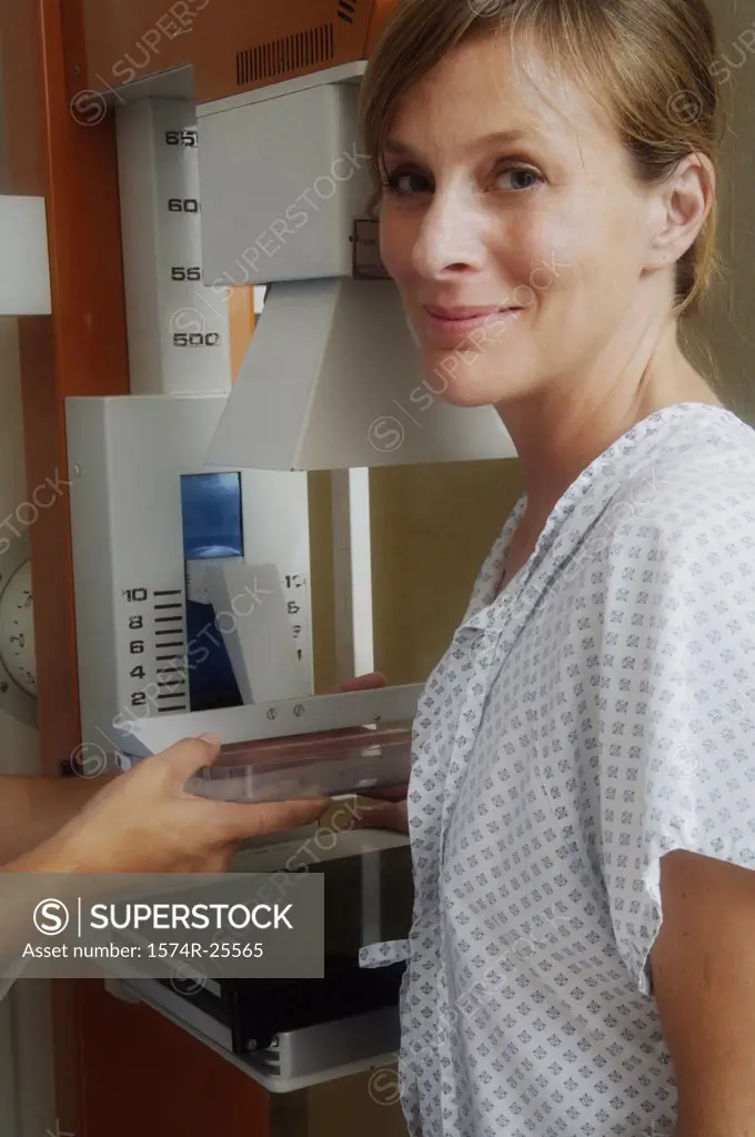 Young woman grinning in front of mammogram equipment