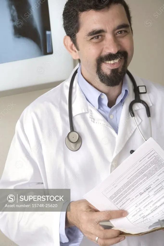 Male doctor holding a clipboard and smiling