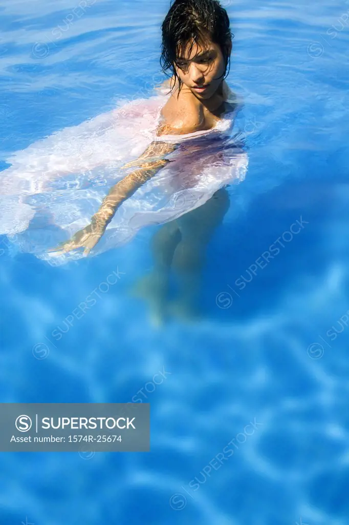 High angle view of a young woman standing in water in a swimming pool