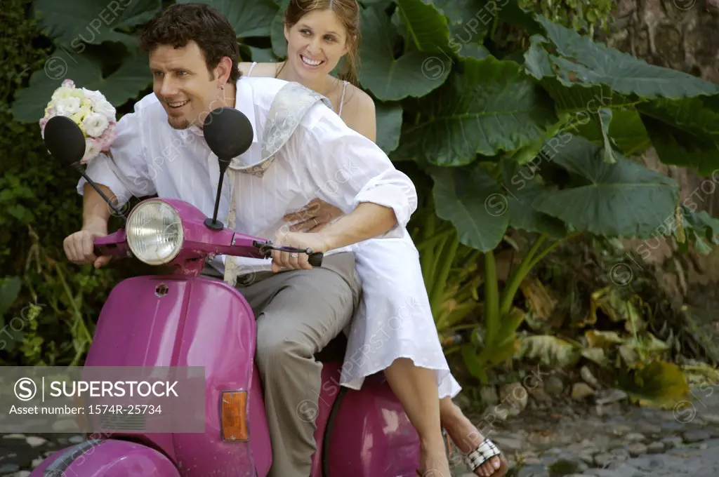 Newlywed couple riding a motor scooter