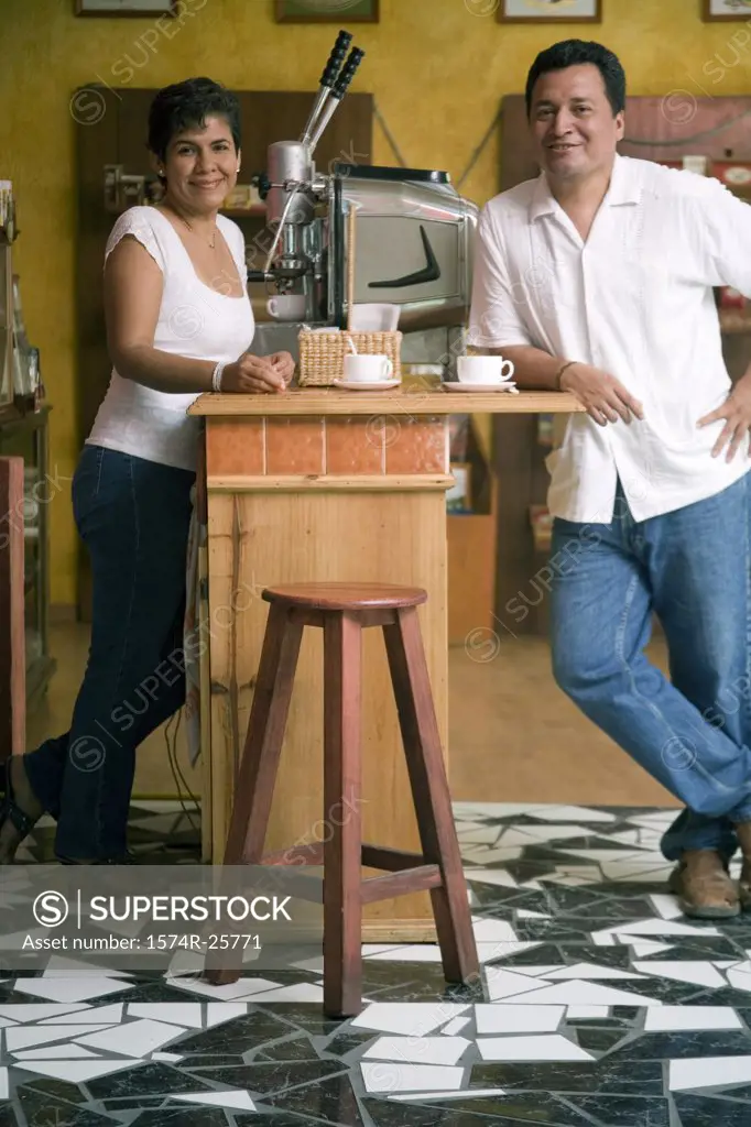 Mature couple leaning against a counter in a cafe