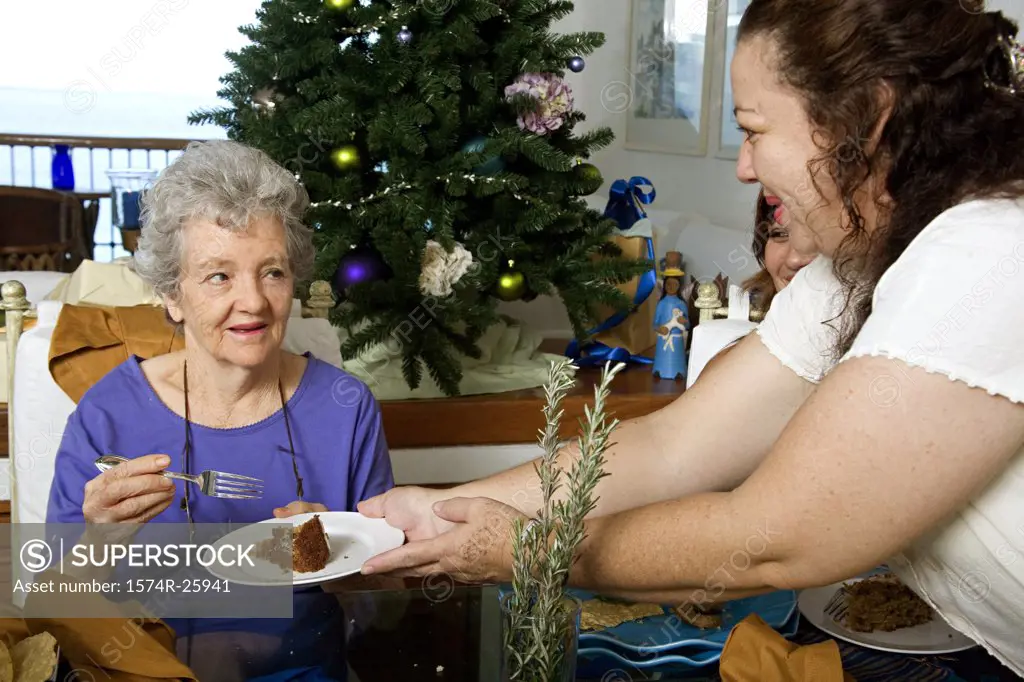 Mature woman giving a cake to a senior woman