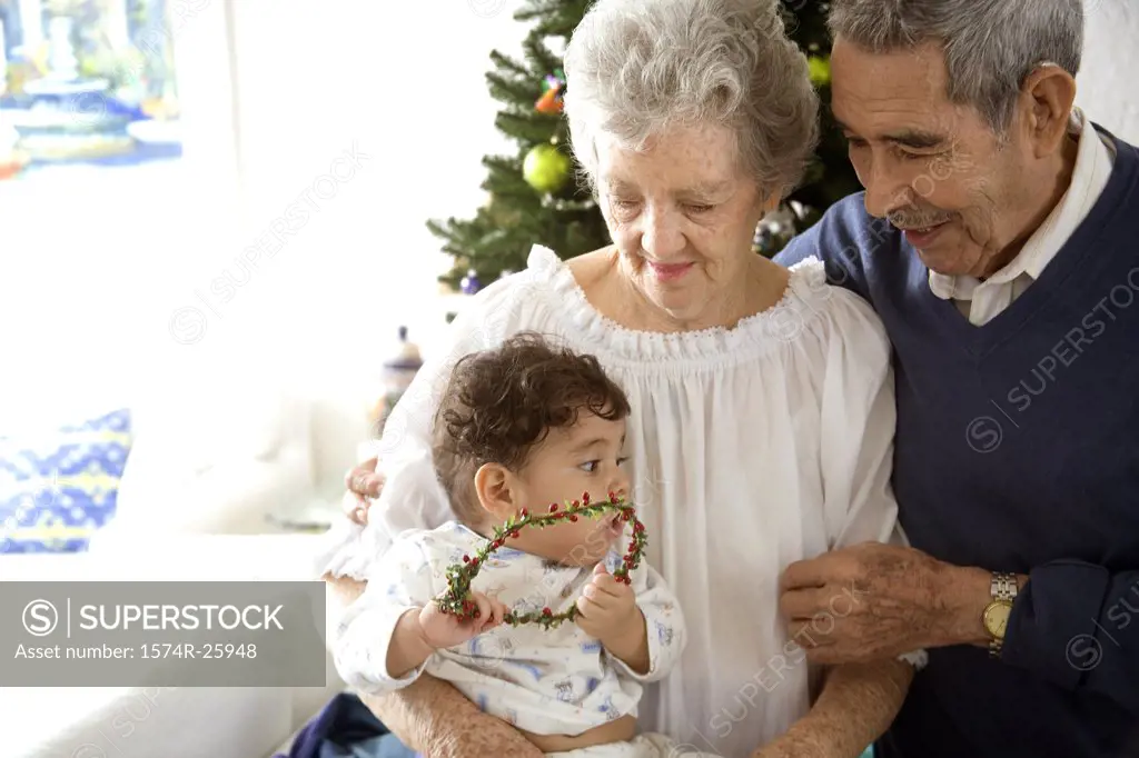 Senior couple looking at their great-grandchild and smiling