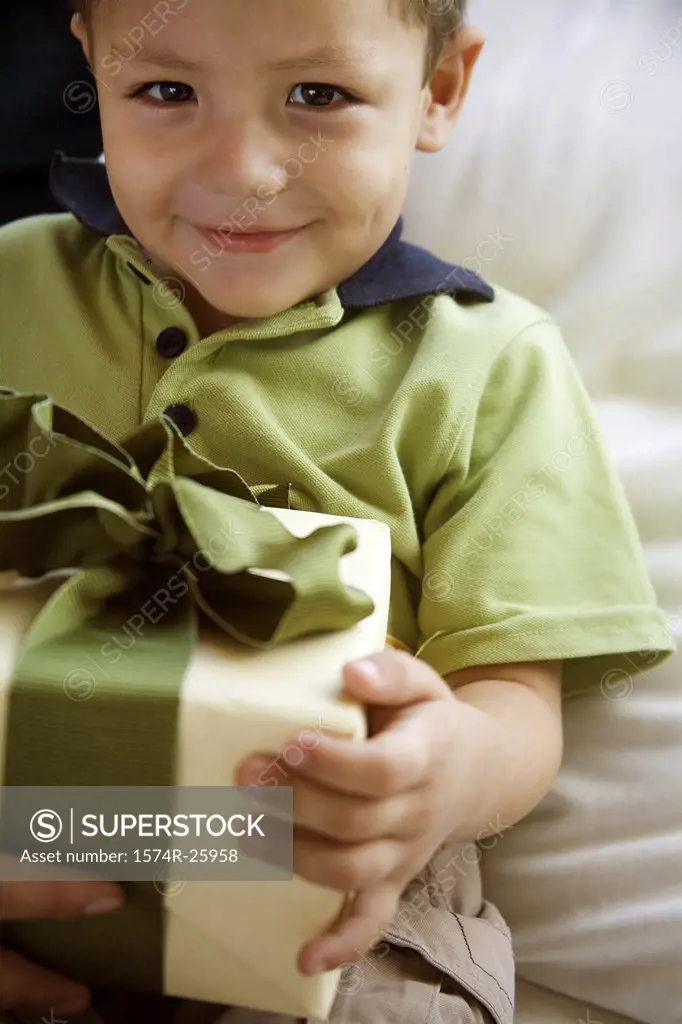 Close-up of a boy holding a gift and grinning