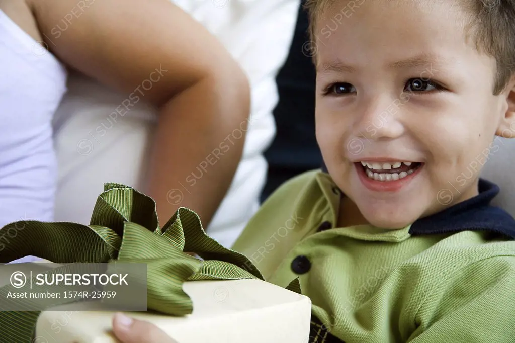 Close-up of a boy holding a gift and smiling