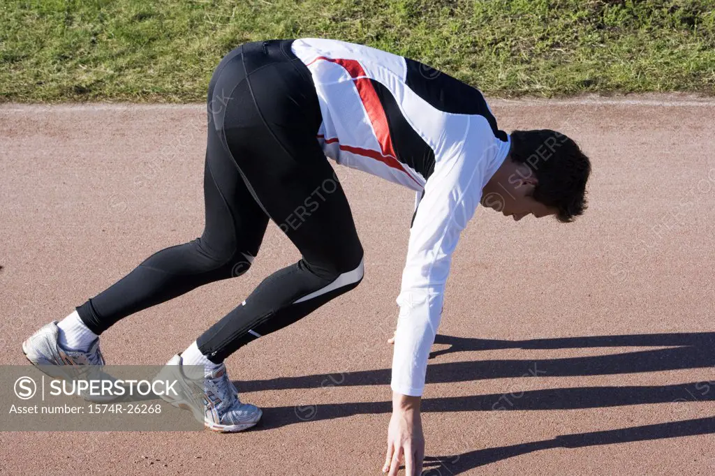 Mid adult man preparing to run