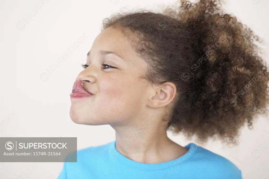 Close-up of a girl touching her nose with her tongue