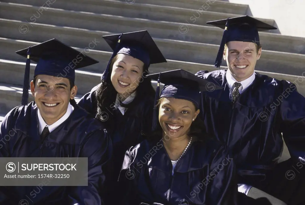 Portrait of a group of young graduates sitting on stairs