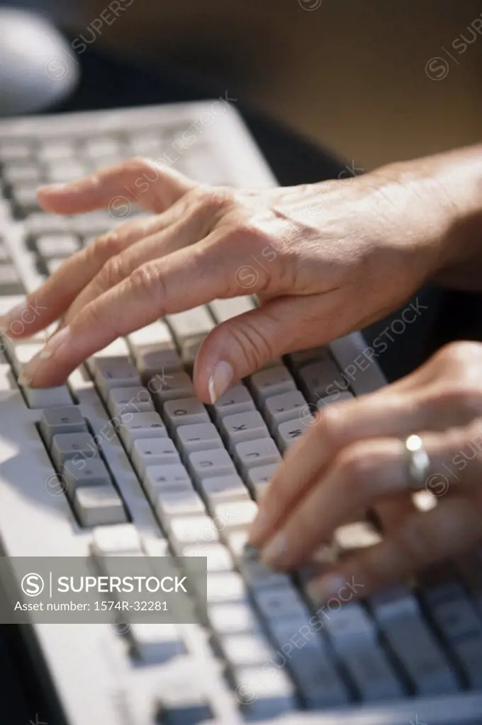 Close-up of a person's hand typing on a computer keyboard