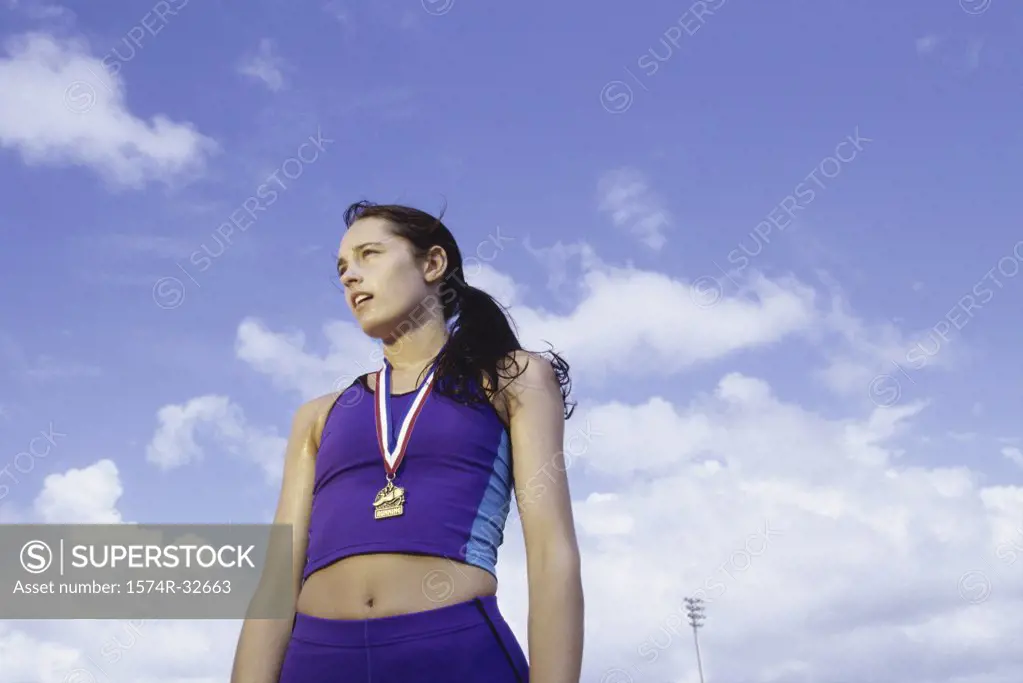 Low angle view of a young woman with a medal around her neck