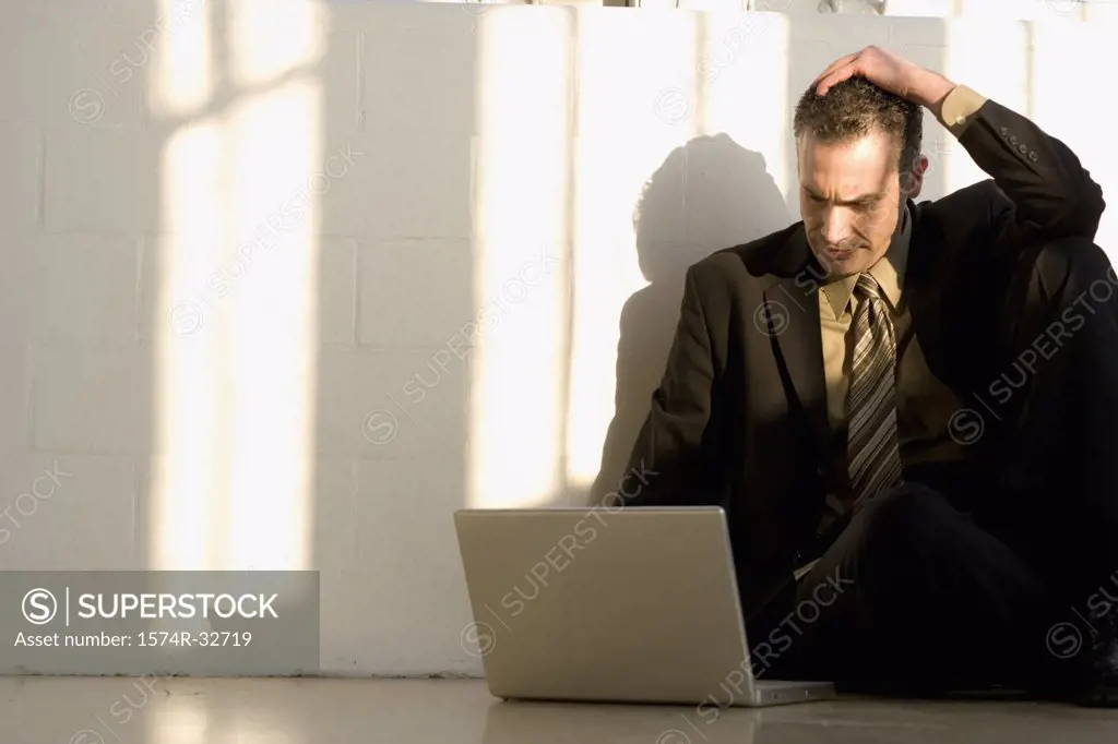 Businessman sitting on the floor and using a laptop