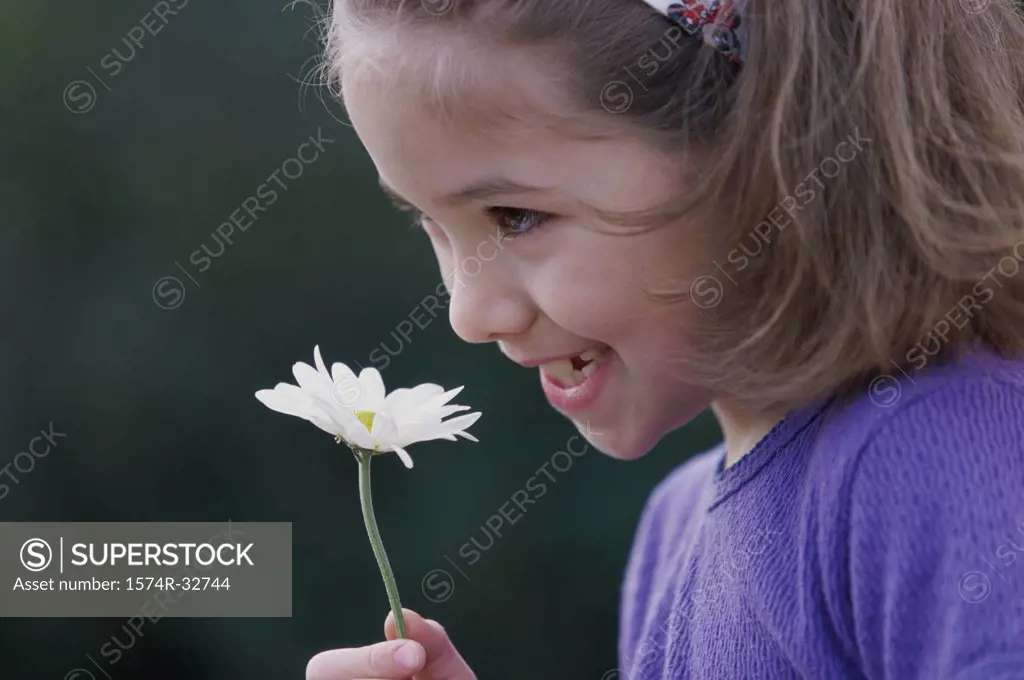 Side profile of a girl holding a flower