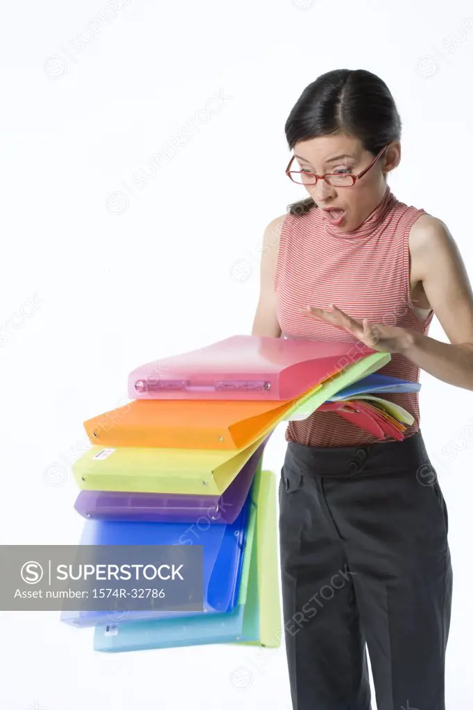 Stack of ring binders falling from a businesswoman's hands