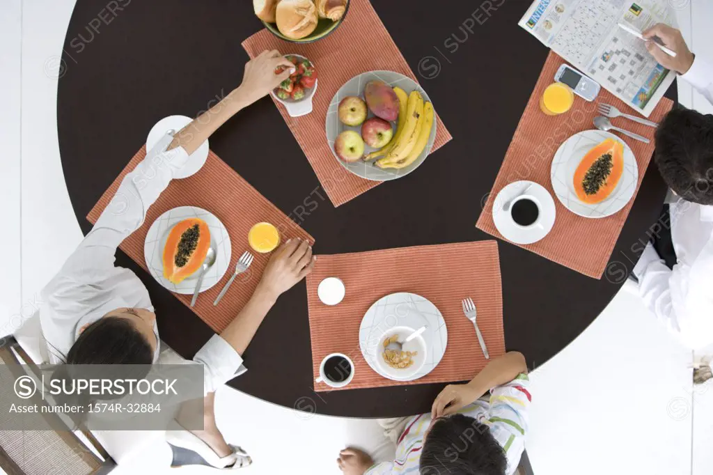 High angle view of a family sitting at a table and having breakfast