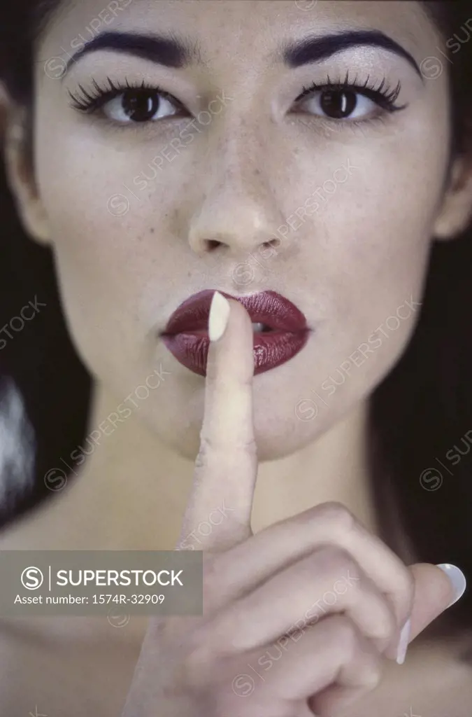 Portrait of a young woman with her finger on her lip