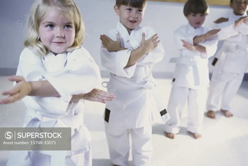 Girl and three boys practicing karate