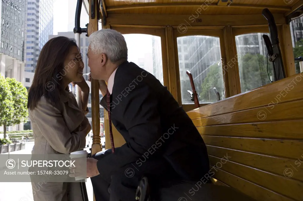 Mature couple looking at each other on a streetcar, San Francisco, California, USA