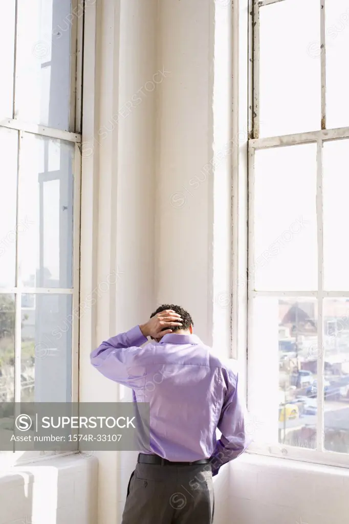Rear view of a businessman standing in the corner of an office