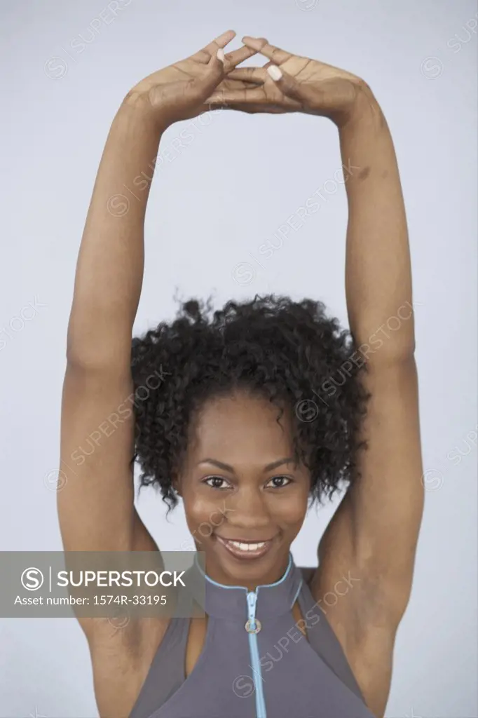 Portrait of a young woman smiling with her arms raised