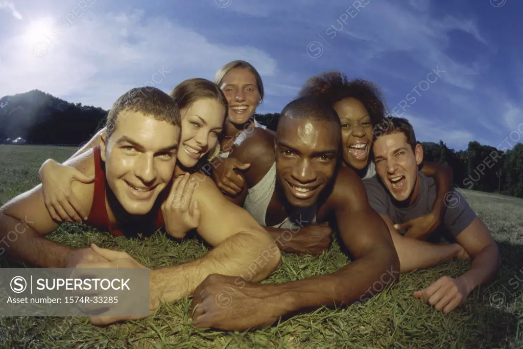 Portrait of a group of young people lying on a lawn together