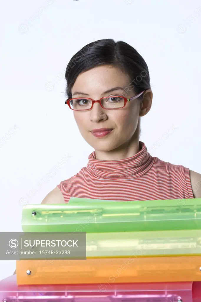 Portrait of a businesswoman holding a stack of ring binders
