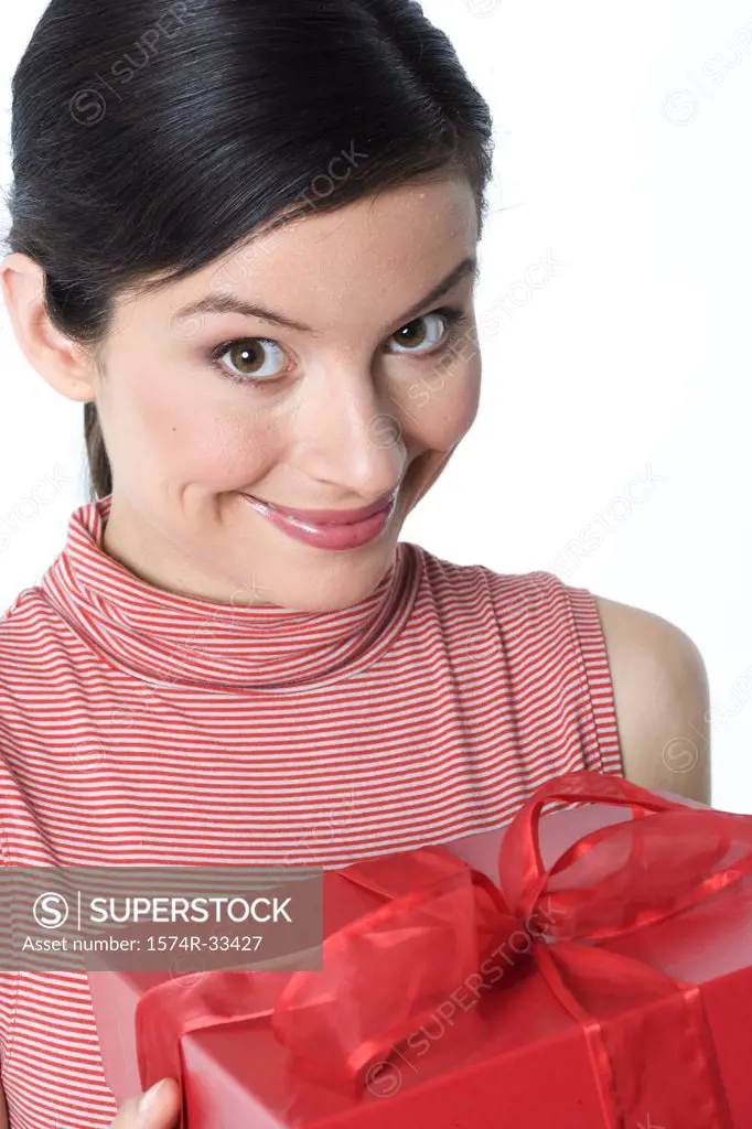 Portrait of a young woman holding a gift and smiling