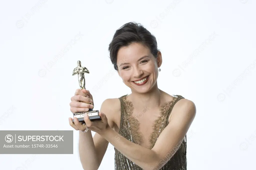 Portrait of a young woman holding a trophy and smiling