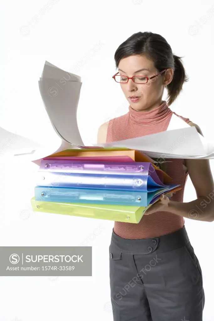 Businesswoman holding a stack of ring binders