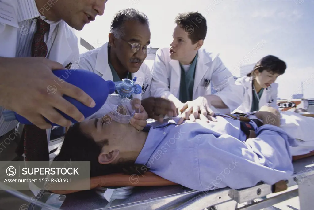 Group of doctors resuscitating a man lying on a stretcher