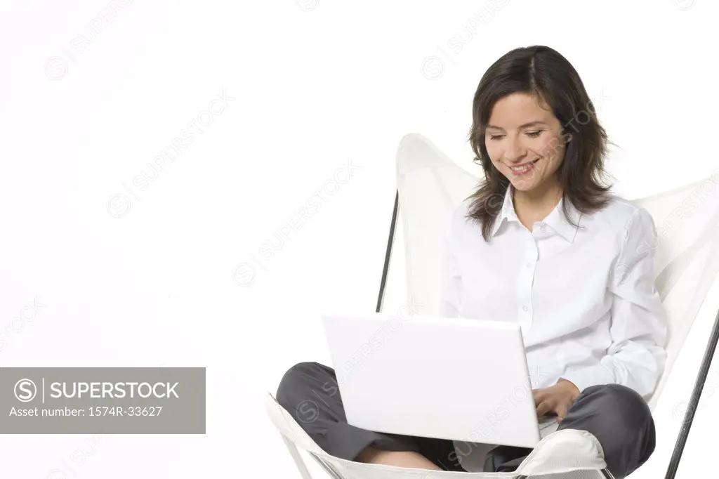 Young woman working on a laptop and smiling