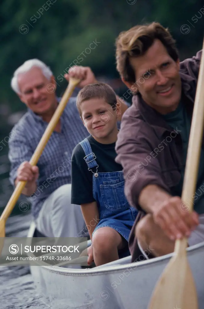 Senior man with his son and grandson rowing a boat