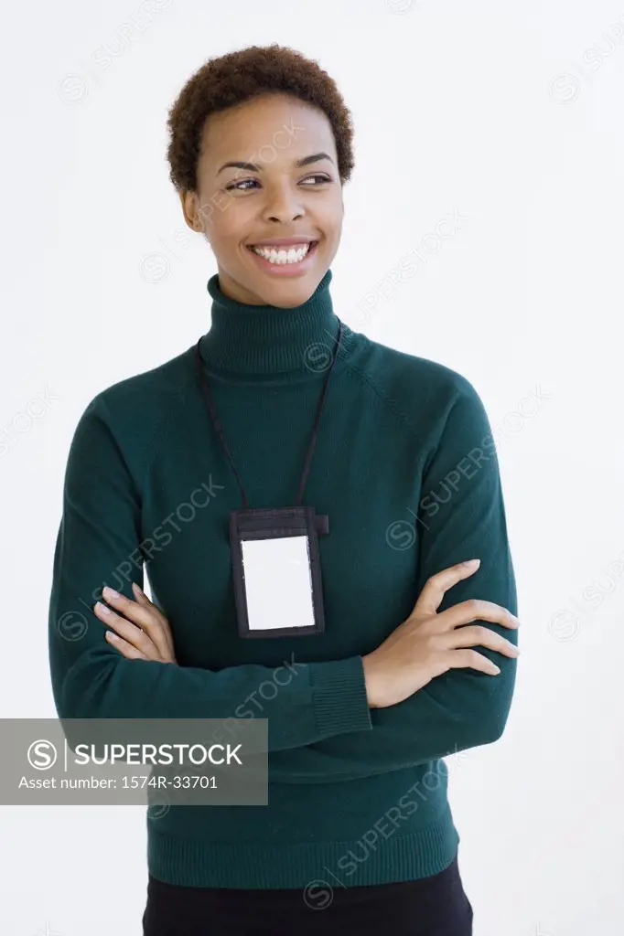 Businesswoman with her arms crossed wearing an id card around her neck