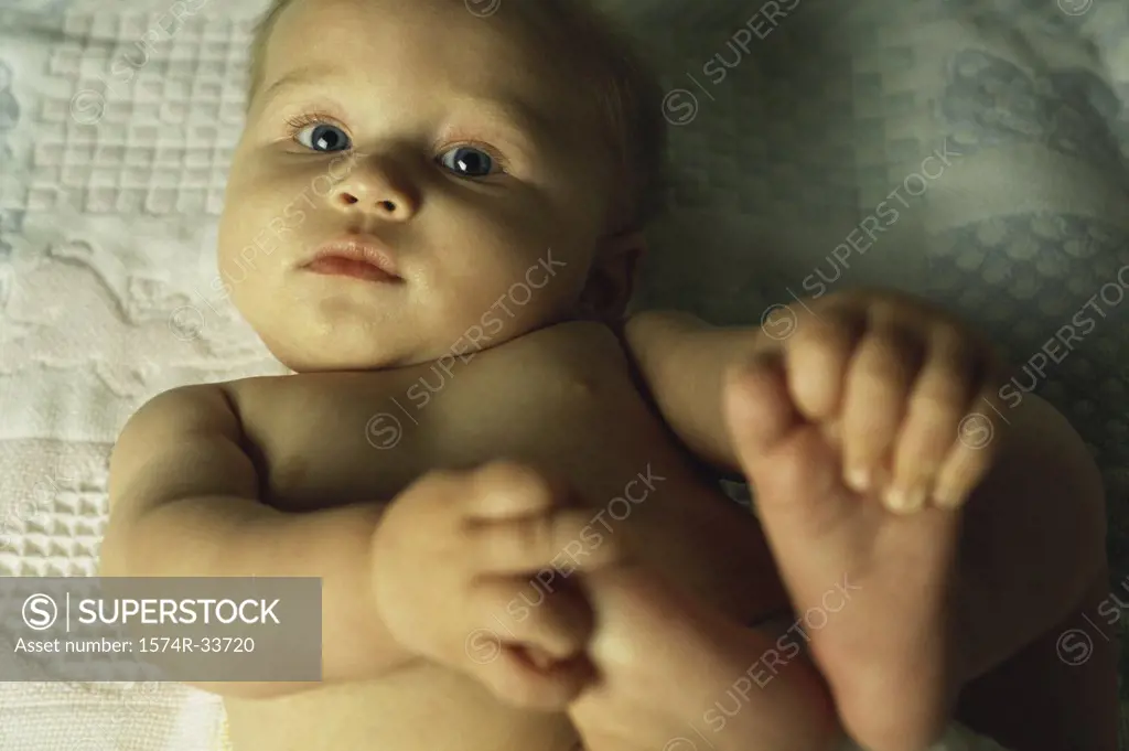 Portrait of a baby boy holding his feet