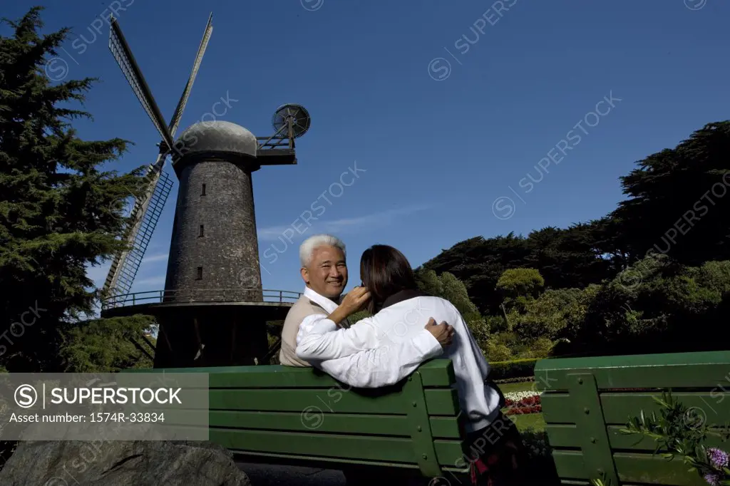 Rear view of a mature couple sitting on a bench in a park, Golden Gate Park, San Francisco, California, USA