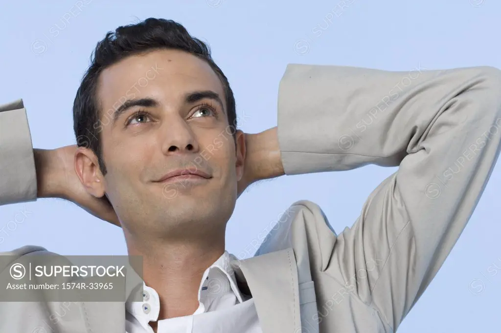 Close-up of a businessman with his hands behind his head